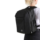 Person wearing a black modular backpack on a white background. 