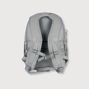 The back view of a light gray backpack, showing the padded mesh backrest, adjustable shoulder straps, and compression buckles, set against a solid light gray background.